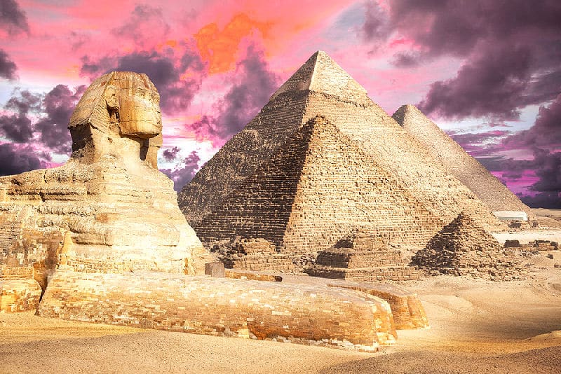 Blick auf die Pyramiden in Gizeh mit Sphinx im Vordergrund.