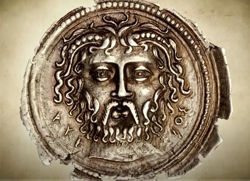 Der Gott Zeus mit seinem typischen Bart und kräftigem Haar auf einer griechischen Münze.